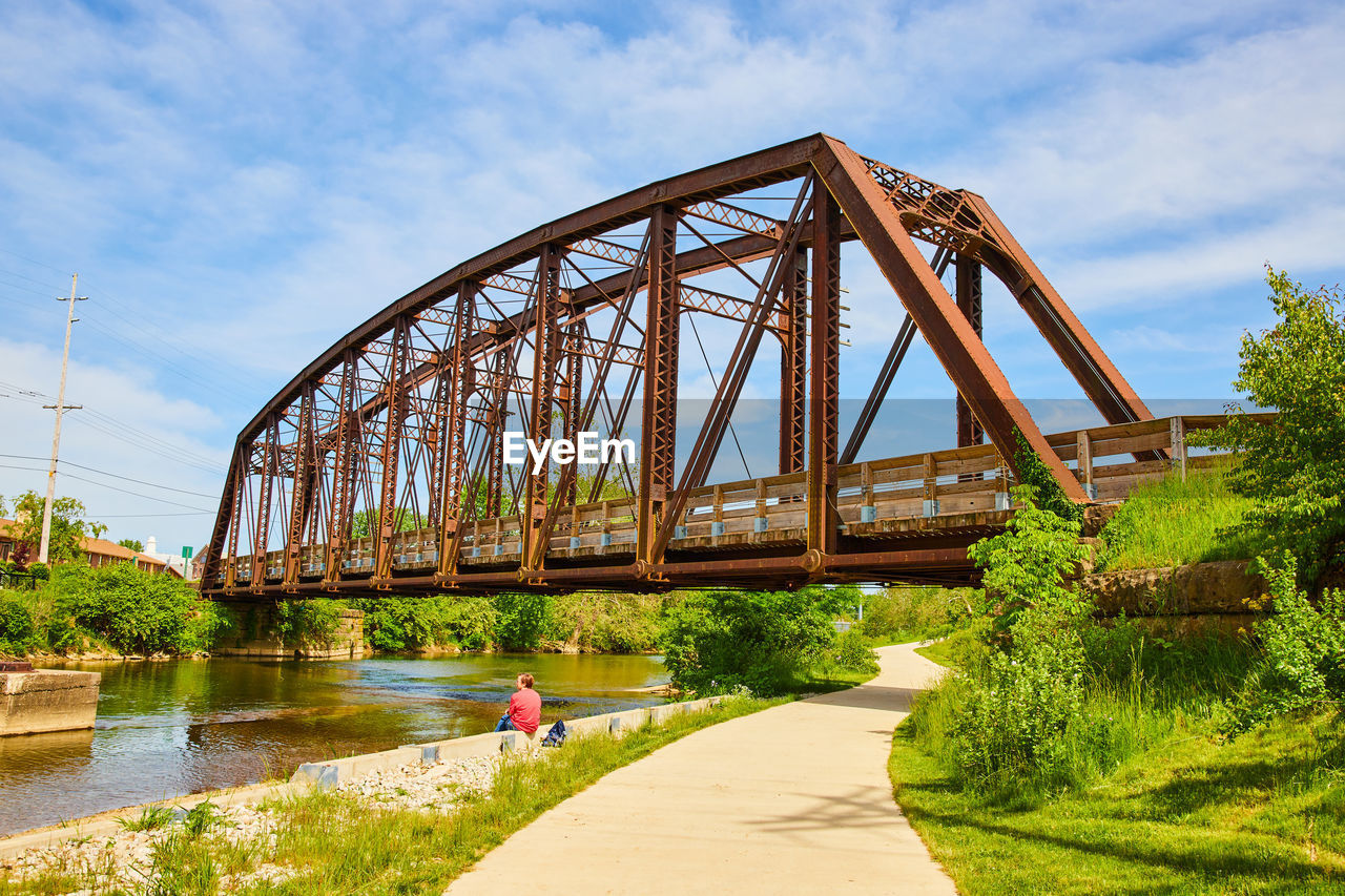 bridge over river against cloudy sky