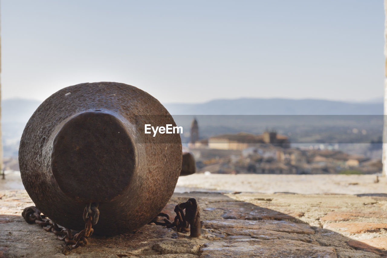 Close-up of old bell clapper in land against sky