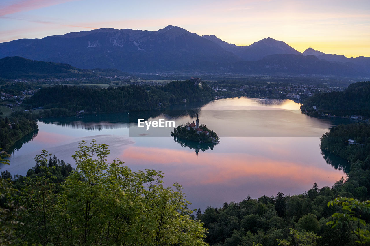 SCENIC VIEW OF LAKE AGAINST SKY AT SUNSET