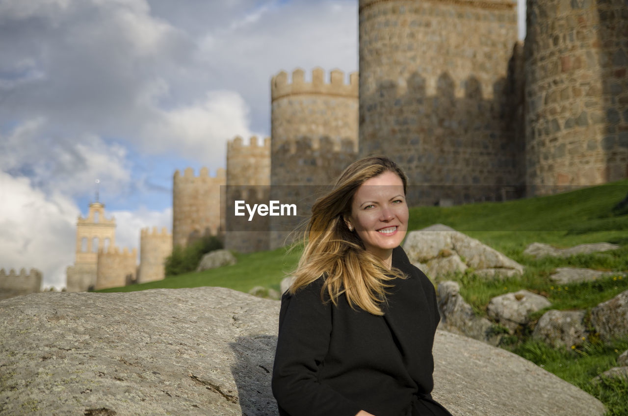 Portrait of smiling woman standing against fort