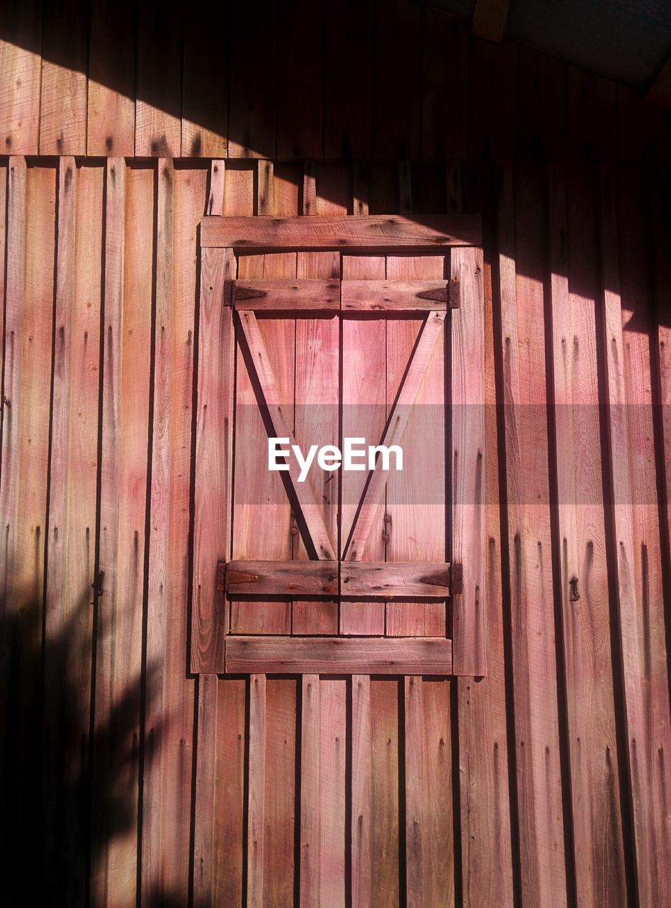 Low angle view of closed window on wooden building