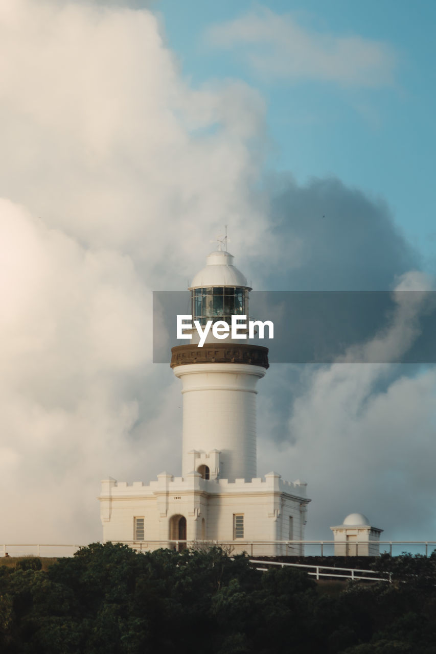 Low angle view of lighthouse by building against sky