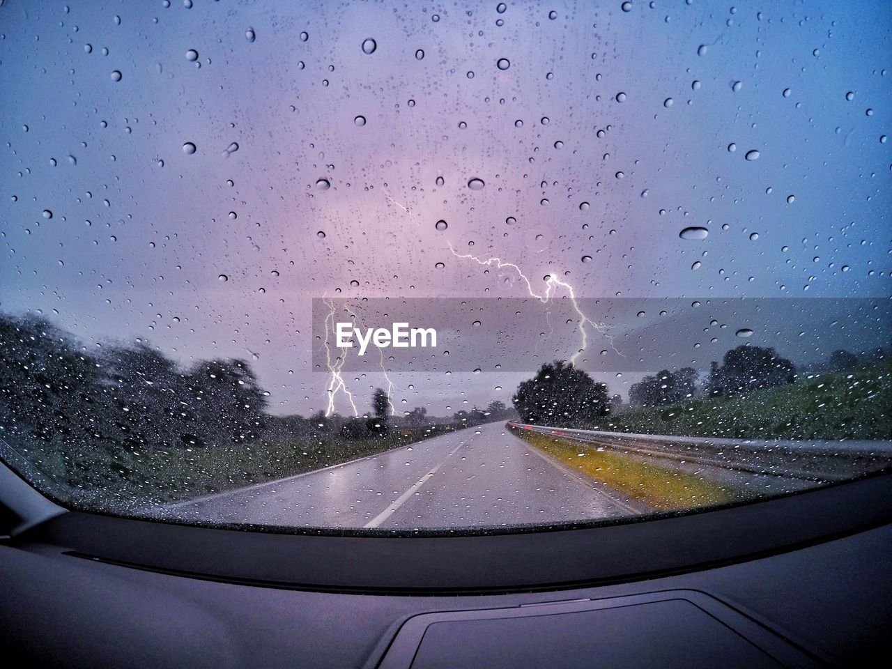 Lightning seen through wet glass windshield