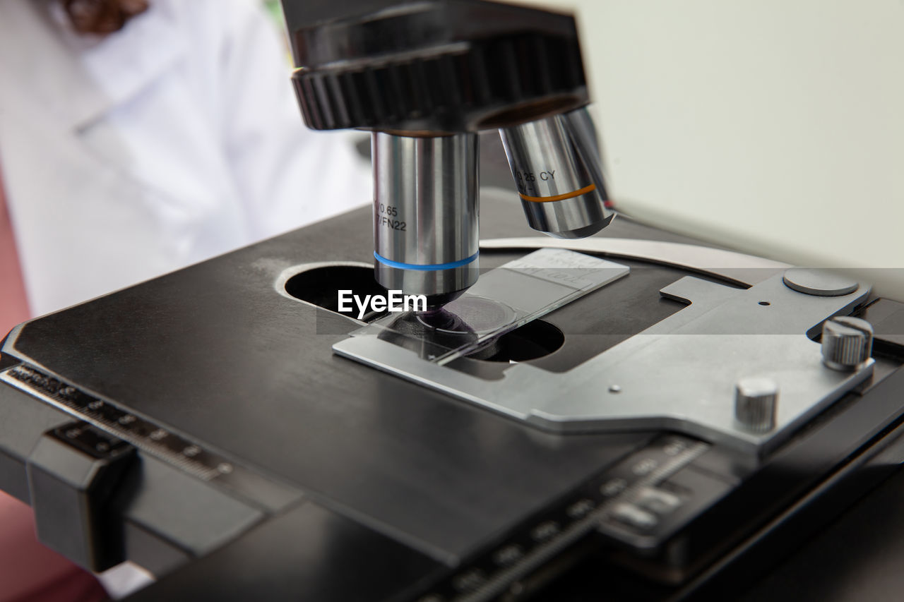 Scientist looking at liquid based cytology pap smear samples through a microscope. 