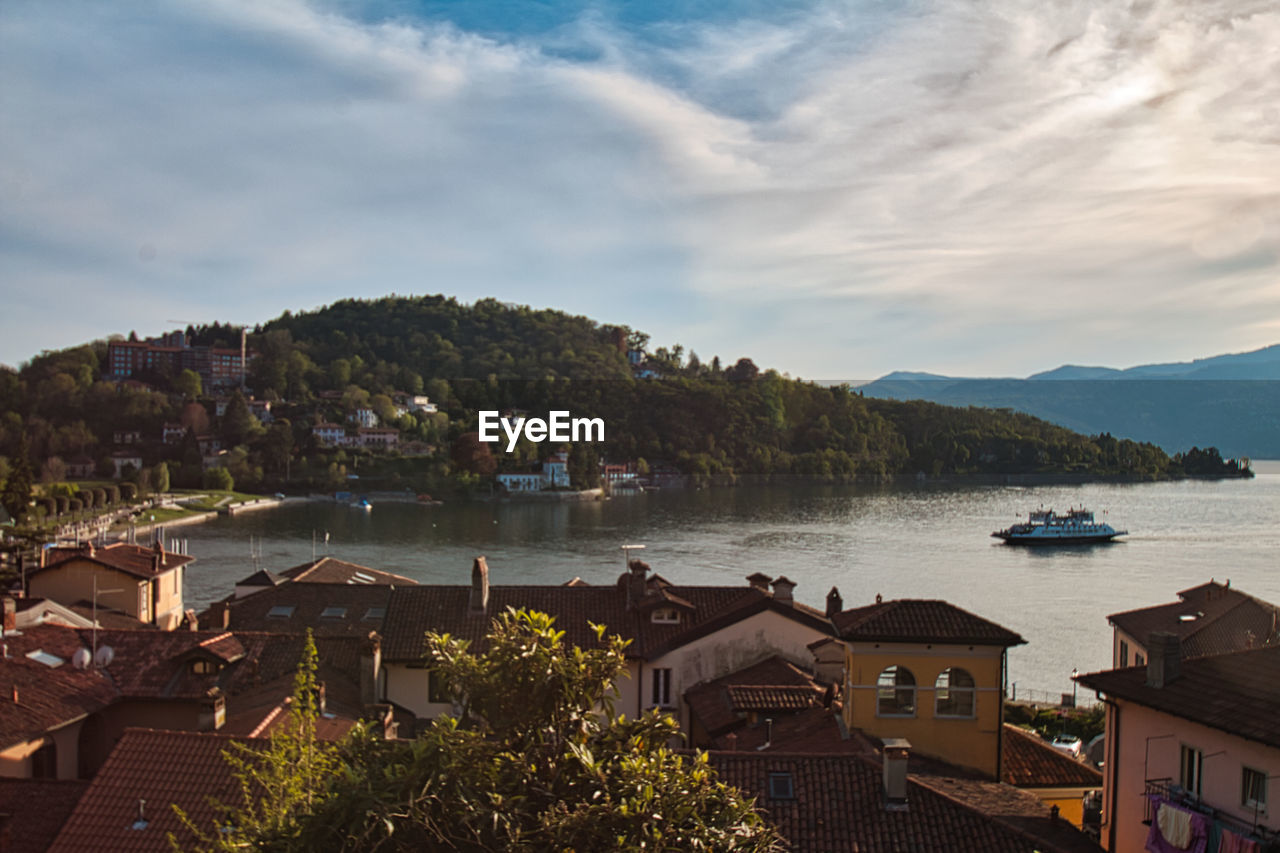 High angle view of townscape by lake against sky