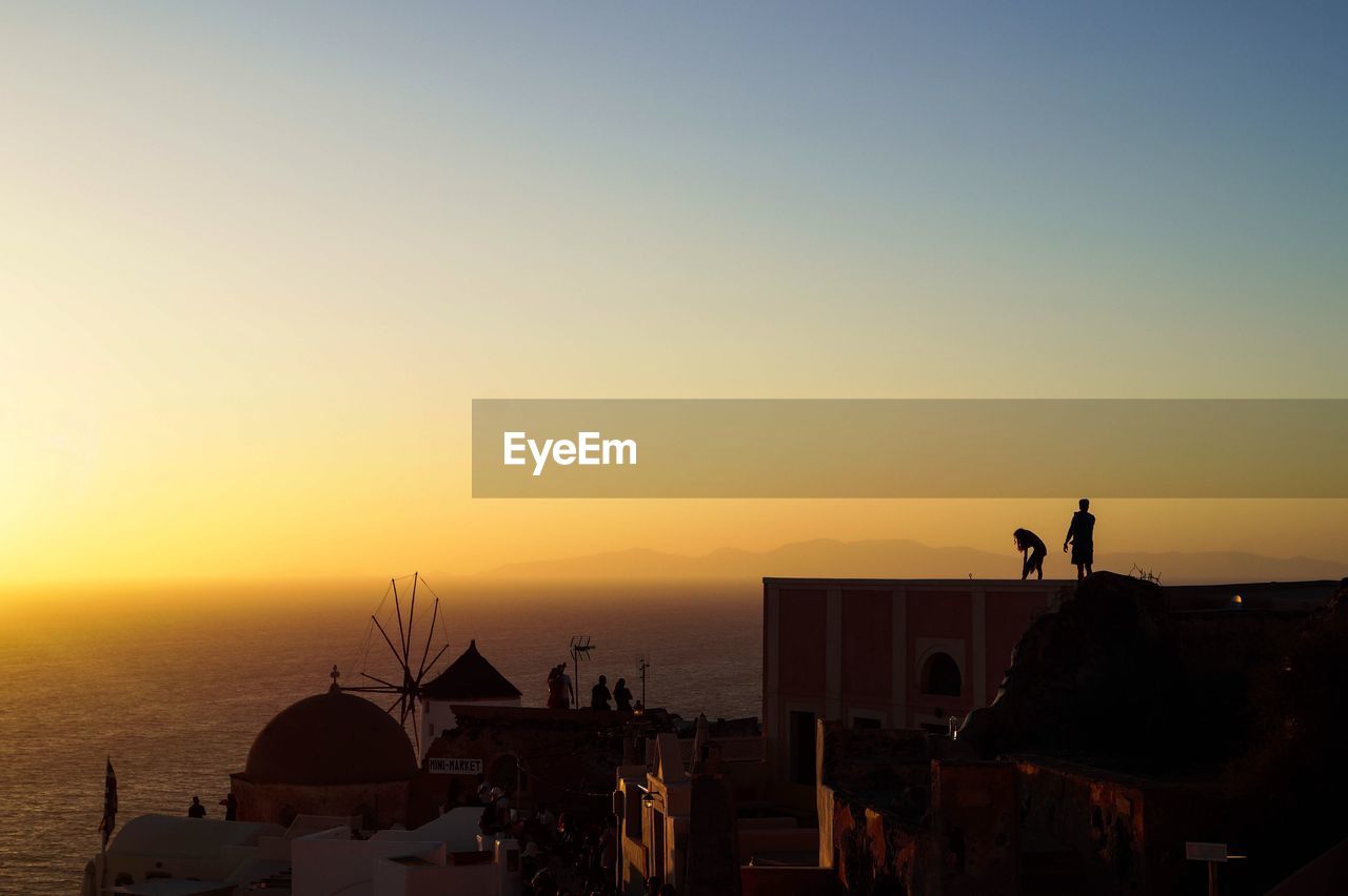 High angle view of buildings against sea during sunset