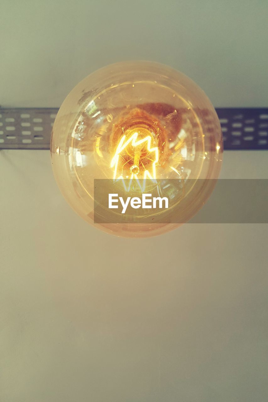 CLOSE-UP OF LIGHT BULB ON WALL