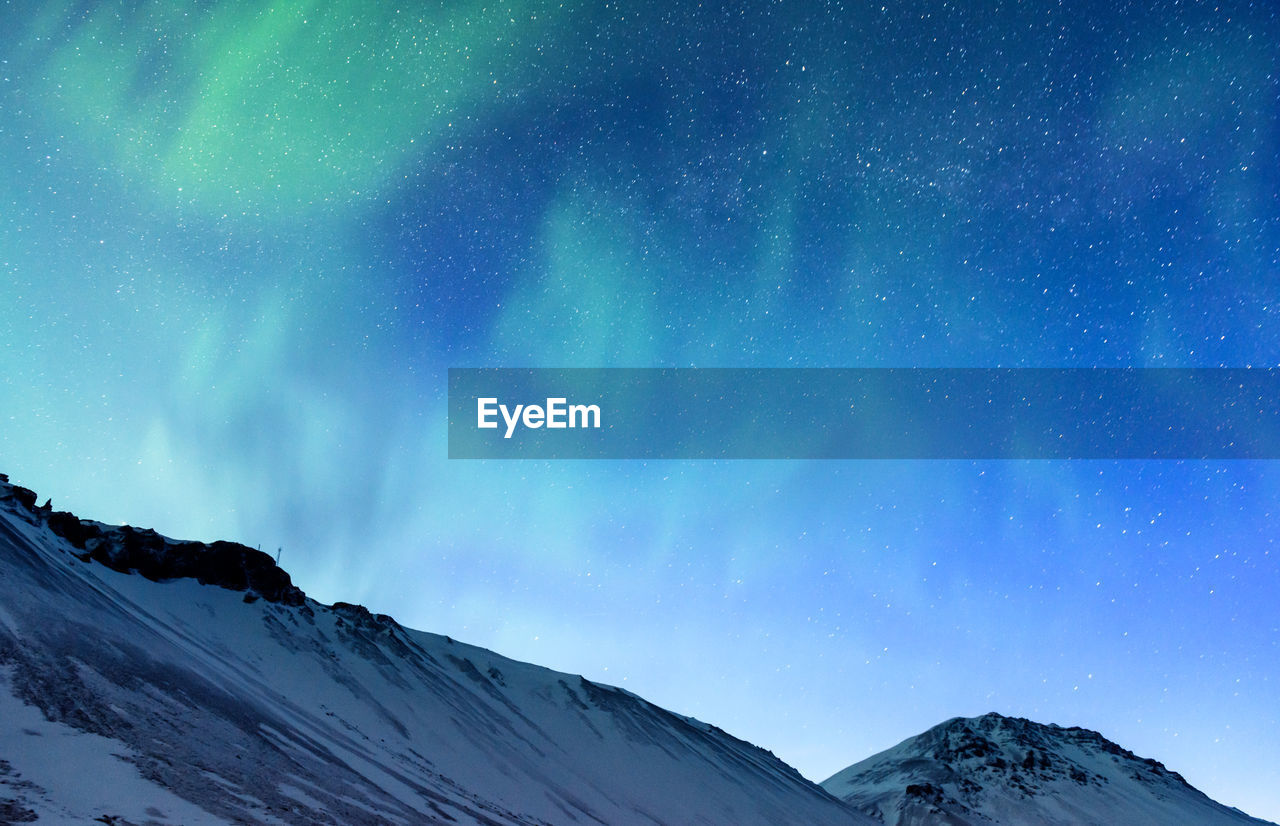 scenic view of snowcapped mountains against blue sky