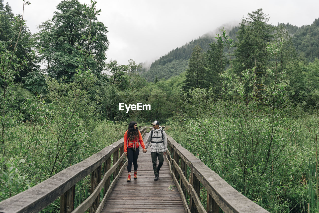 A young couple hikes on a trail in mt. hood national forest in oregon.