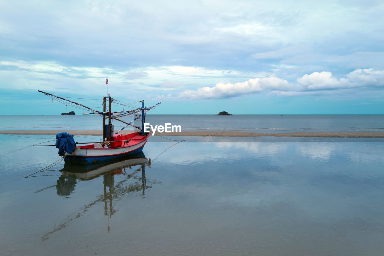 FISHING BOAT MOORED ON SEA AGAINST SKY