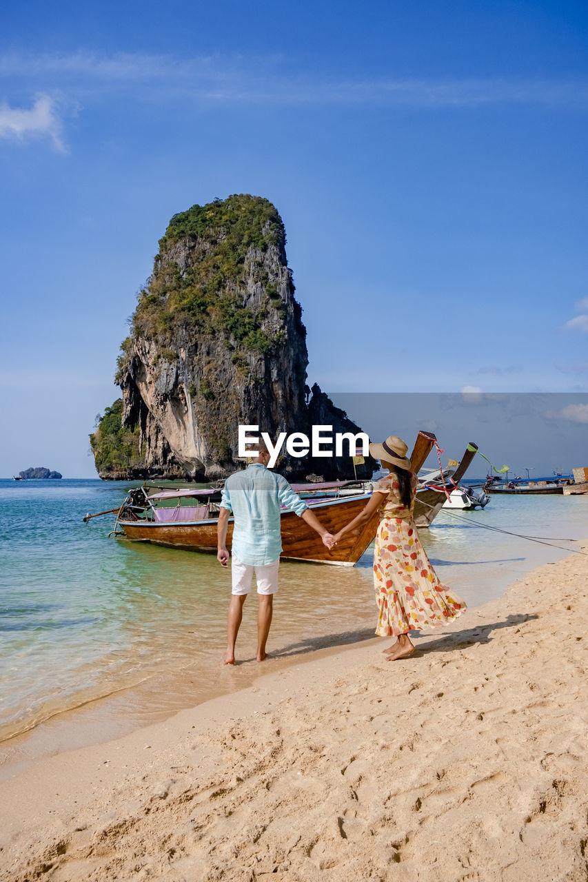 REAR VIEW OF WOMAN ON BEACH