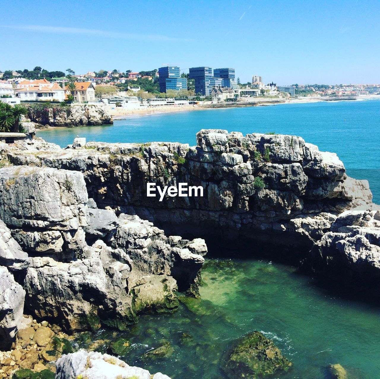 Scenic view of city by ocean against clear sky