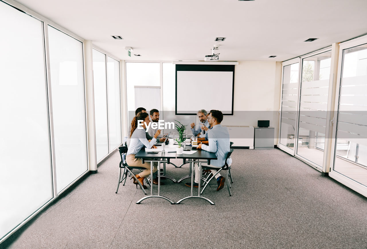 Business people discussing while sitting in board room