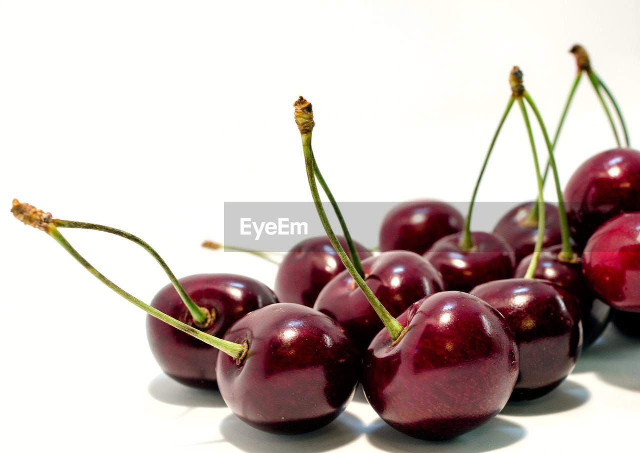 CLOSE-UP OF CHERRIES AGAINST BLUE BACKGROUND