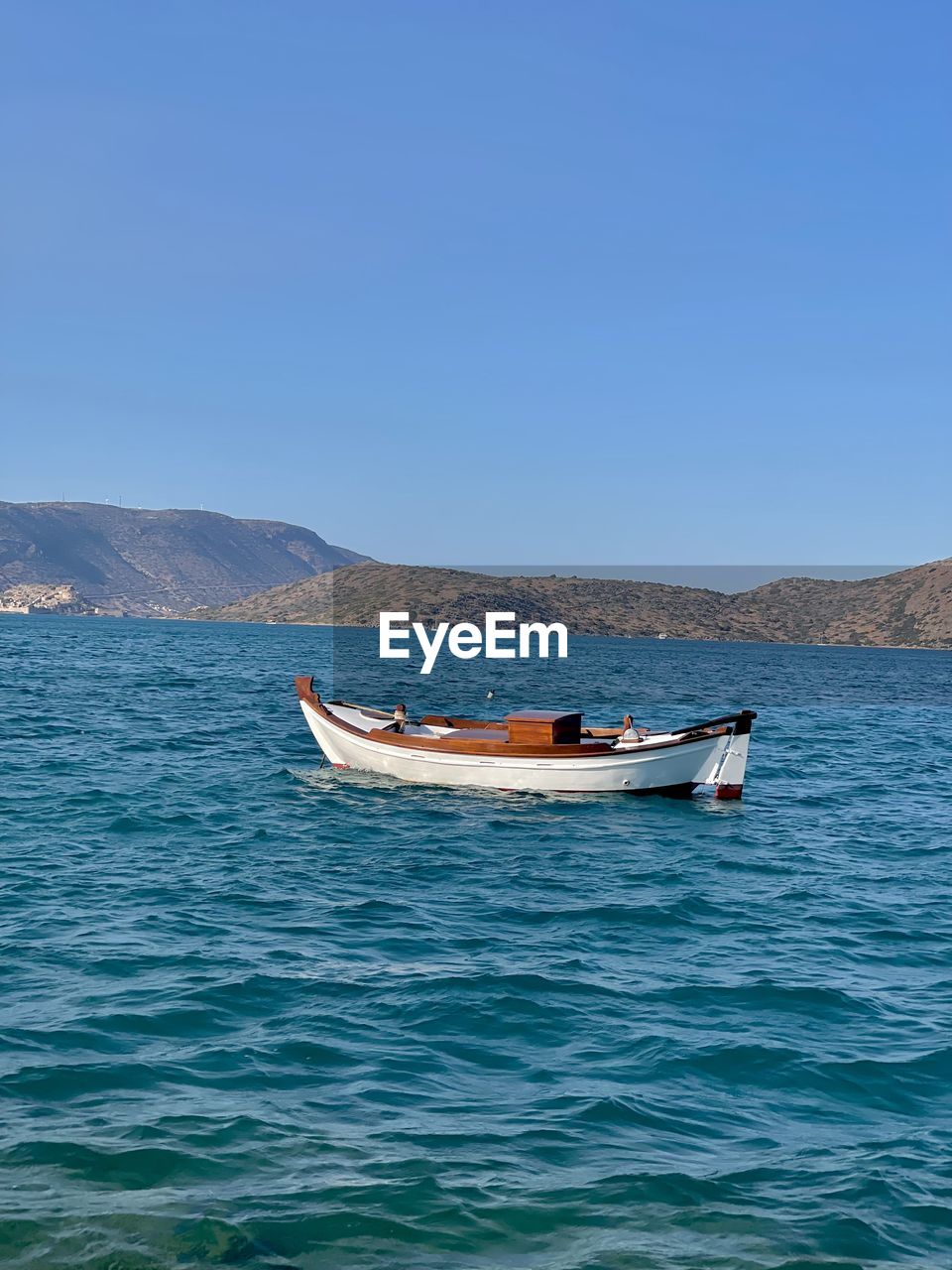 water, nautical vessel, transportation, mode of transportation, sea, boat, blue, sky, nature, vehicle, travel, clear sky, mountain, boating, scenics - nature, beauty in nature, bay, day, no people, land, travel destinations, outdoors, tranquility, long-tail boat, watercraft, tranquil scene, environment, non-urban scene, sunny, beach, ocean, tourism, copy space