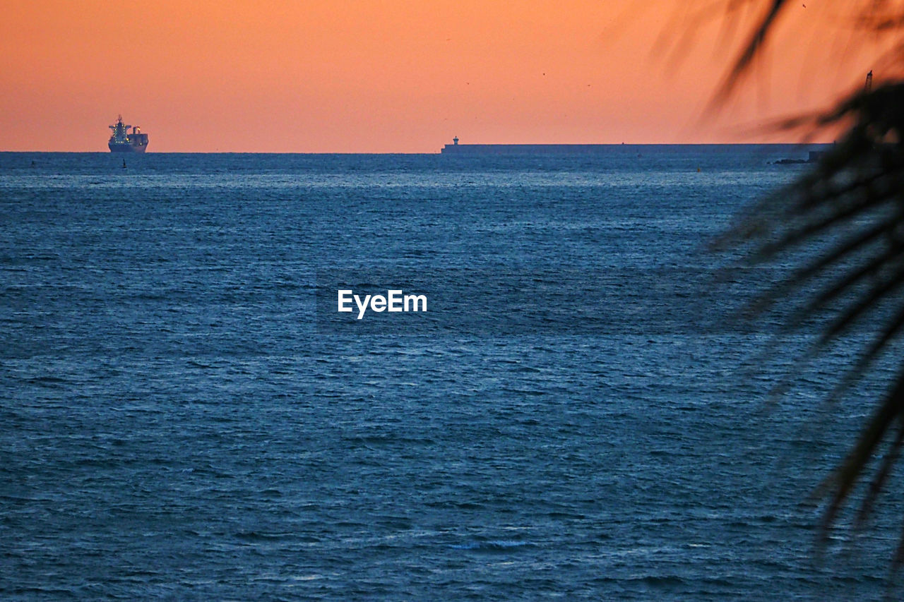 Scenic view of sea against orange sky
