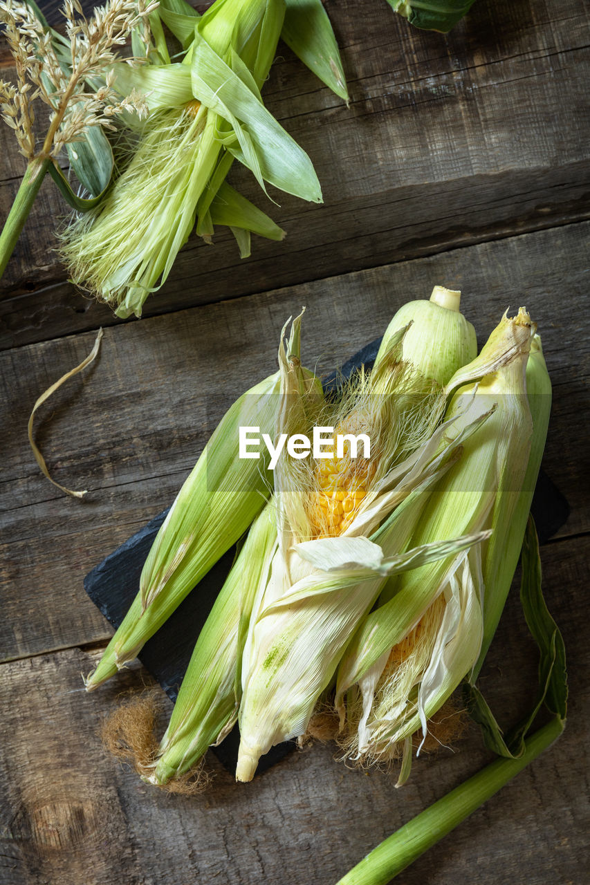 Healthy ripe corn on a wooden kitchen table. the concept of a organic menu.