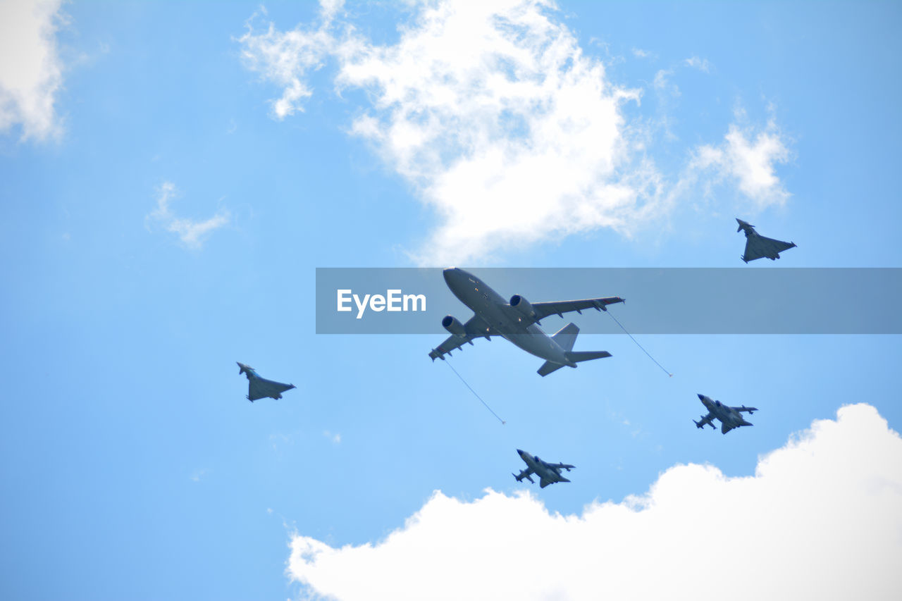 LOW ANGLE VIEW OF AIRPLANE IN FLIGHT AGAINST BLUE SKY