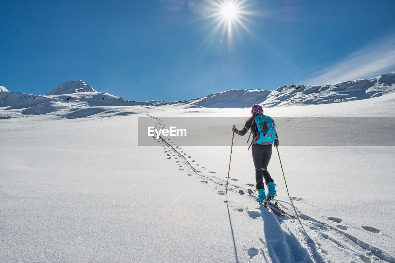 rear view of man walking on snow covered mountain