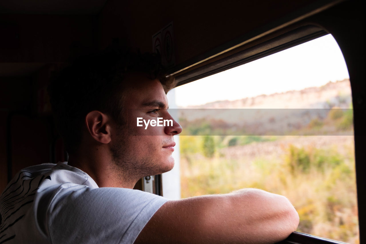 Close-up of man looking through car window