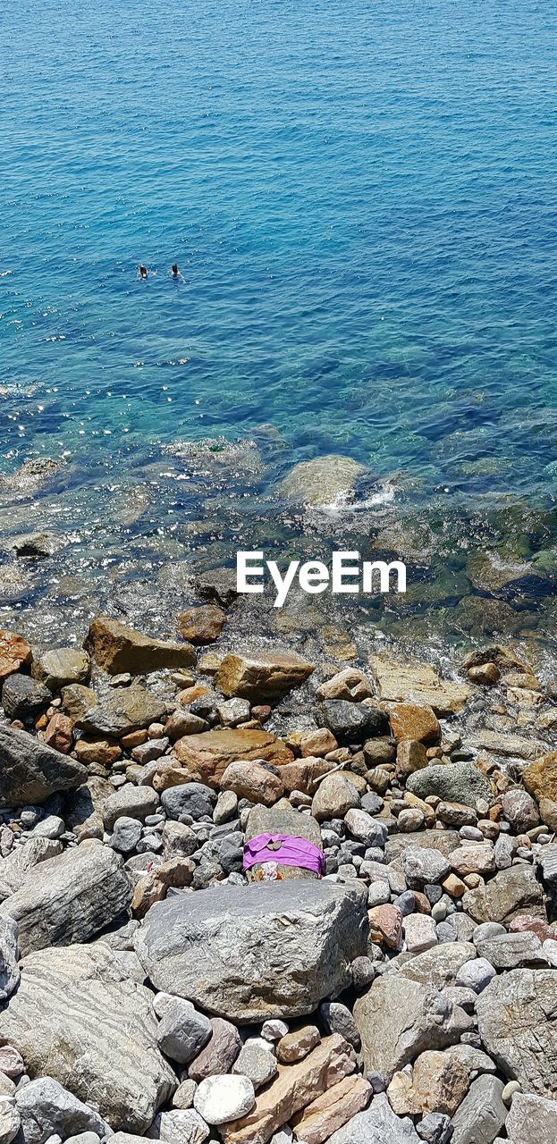 HIGH ANGLE VIEW OF ROCKS BY SEA