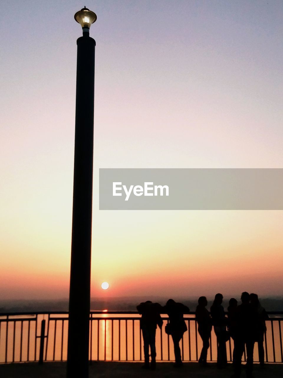 SILHOUETTE PEOPLE STANDING BY SEA AGAINST CLEAR SKY