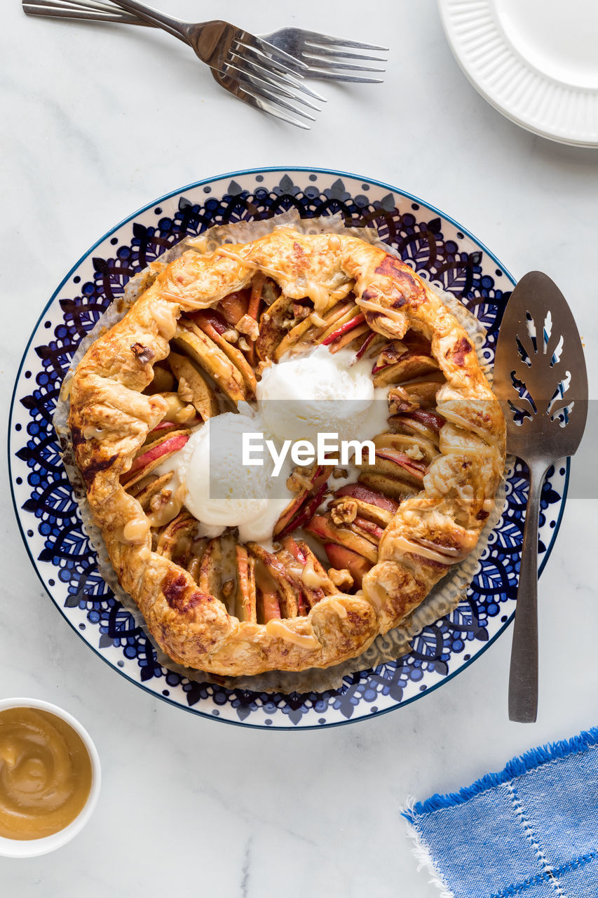 A salted caramel apple galette topped with ice cream, ready for serving.