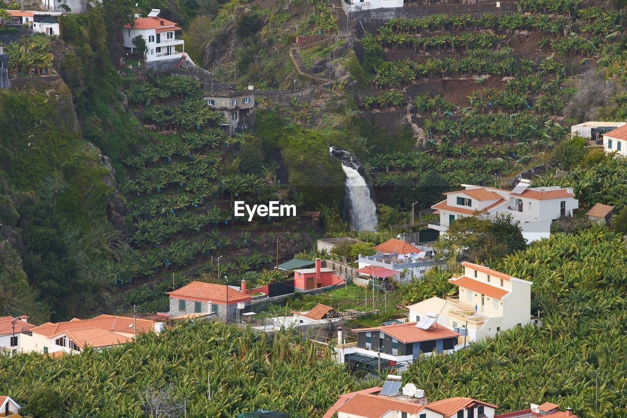 View from miradouro da torre viewpoint of a village in madeira with a waterfall