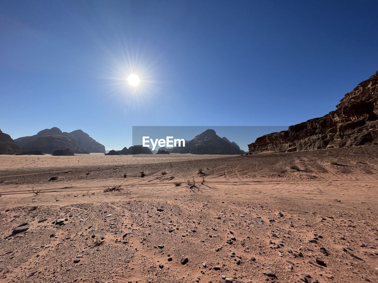sky, landscape, environment, scenics - nature, land, natural environment, desert, mountain, nature, beauty in nature, clear sky, sun, wadi, climate, sunlight, travel, horizon, sand, travel destinations, plateau, sunny, arid climate, blue, no people, dry, non-urban scene, tranquility, valley, soil, mountain range, outdoors, extreme terrain, rock, tranquil scene, semi-arid, accidents and disasters, animal wildlife, tourism, barren, day, remote, cloud, wilderness