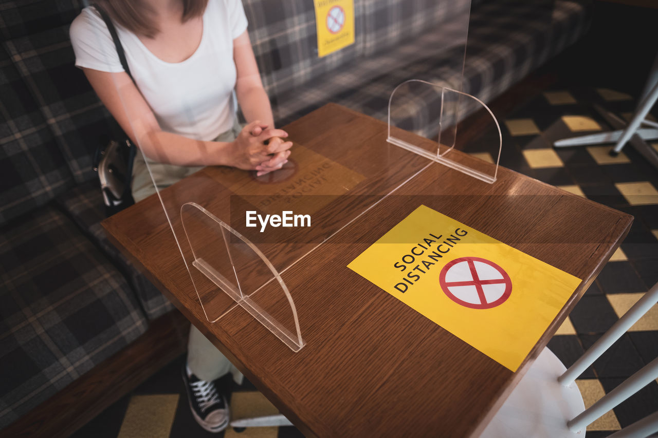 High angle low section of woman sitting in restaurant