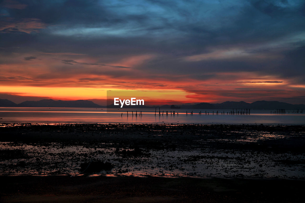 SCENIC VIEW OF BEACH AGAINST SKY DURING SUNSET