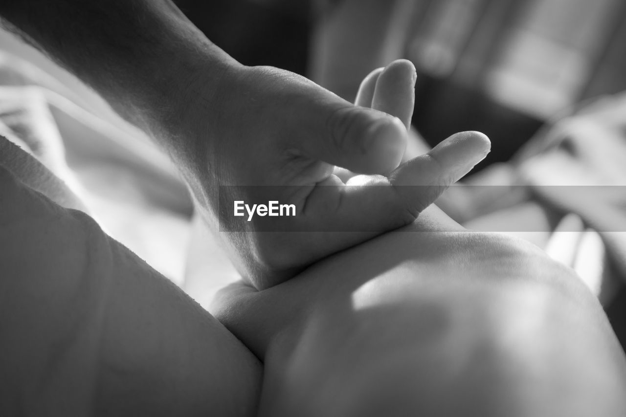 Cropped hand of massage therapist massaging at health spa