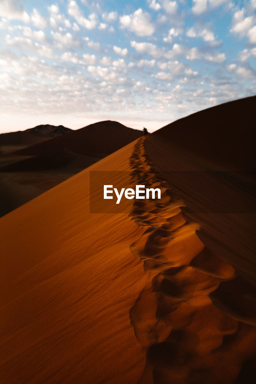 Sand dunes in desert against sky