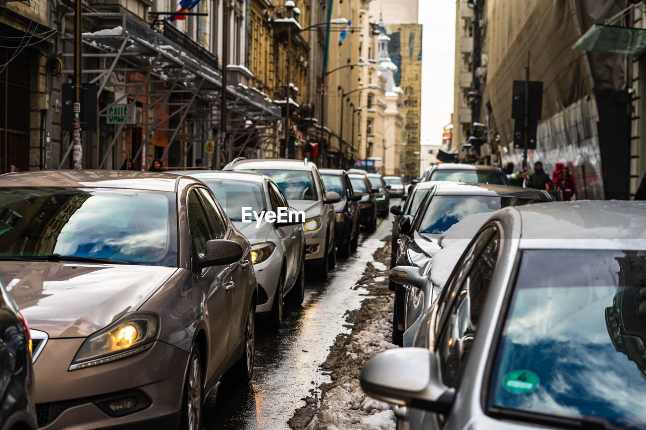 CARS ON STREET AMIDST BUILDINGS IN CITY