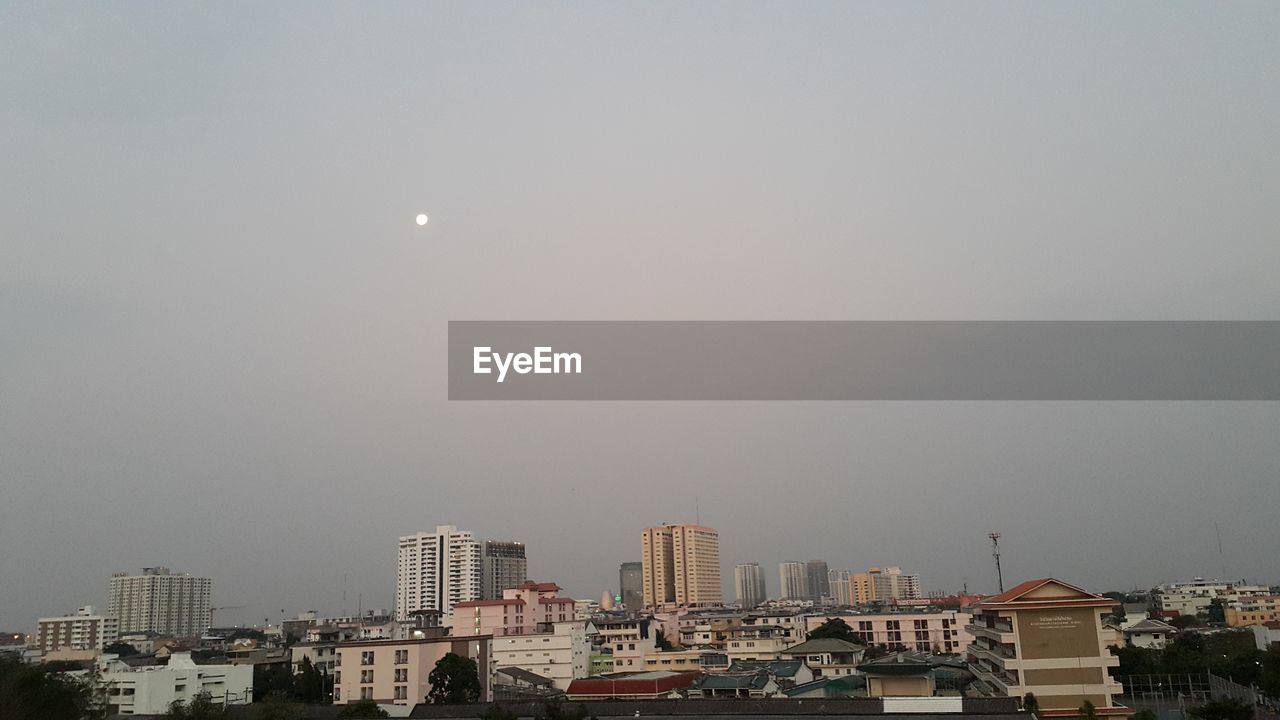 Low angle view of buildings in city against sky at dusk