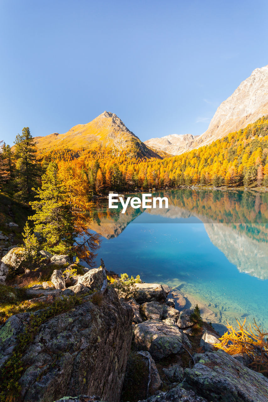 SCENIC VIEW OF LAKE AGAINST MOUNTAIN DURING AUTUMN