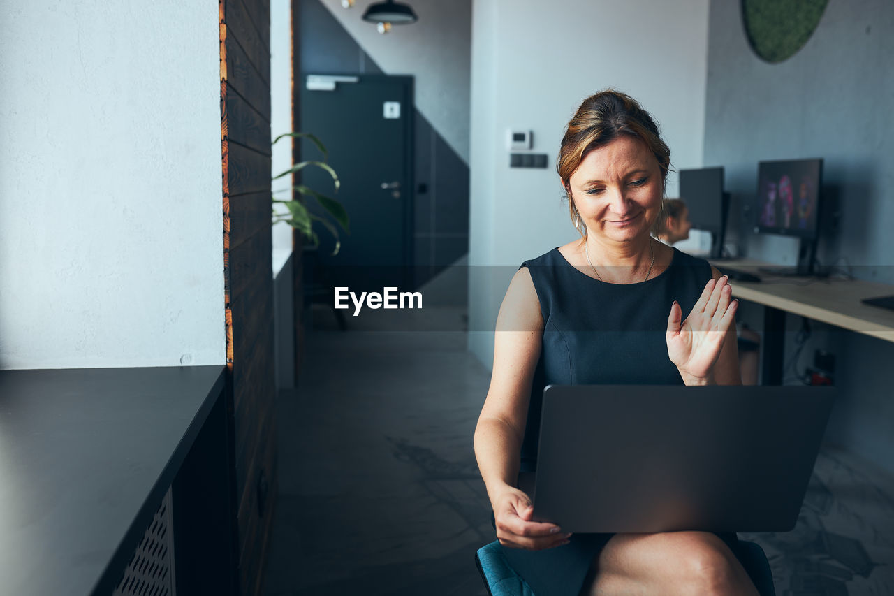 Woman having business video call on laptop in office. mature busy woman remotely working from office