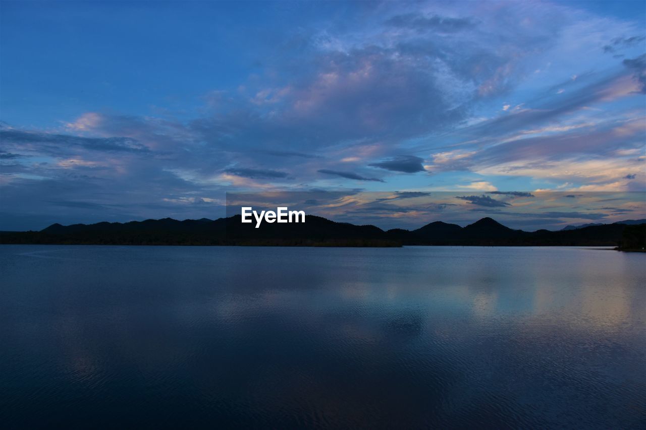 SCENIC VIEW OF LAKE AND MOUNTAINS AGAINST SKY DURING SUNSET