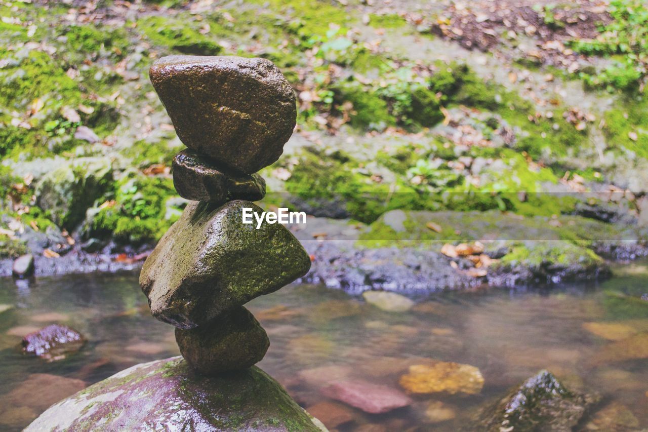 CLOSE-UP OF ROCKS ON WATER