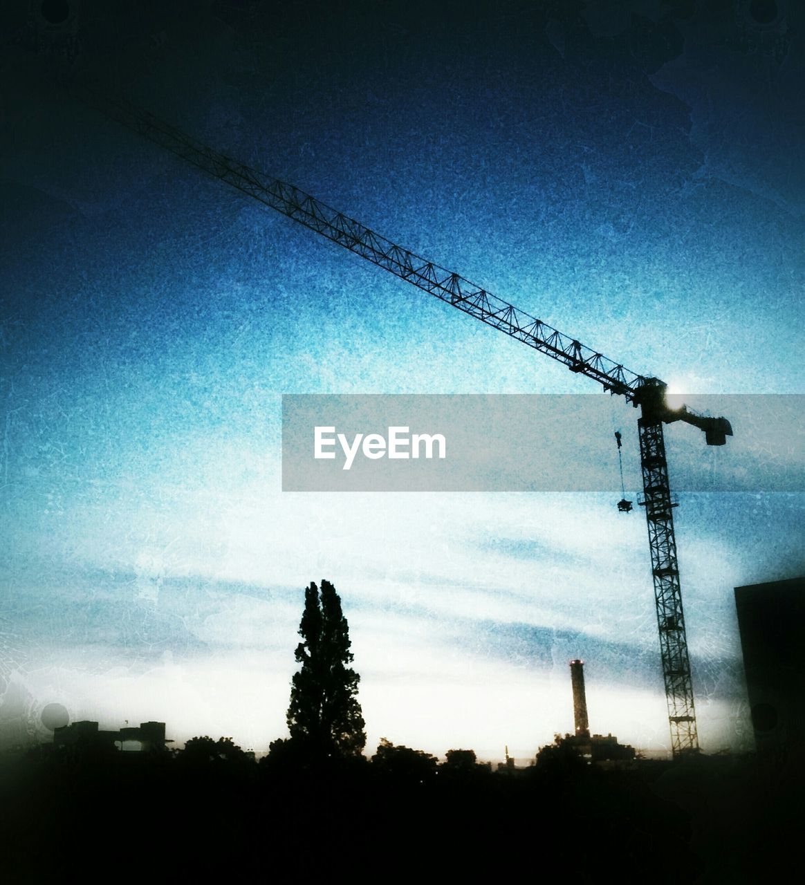 LOW ANGLE VIEW OF CRANES AGAINST SKY