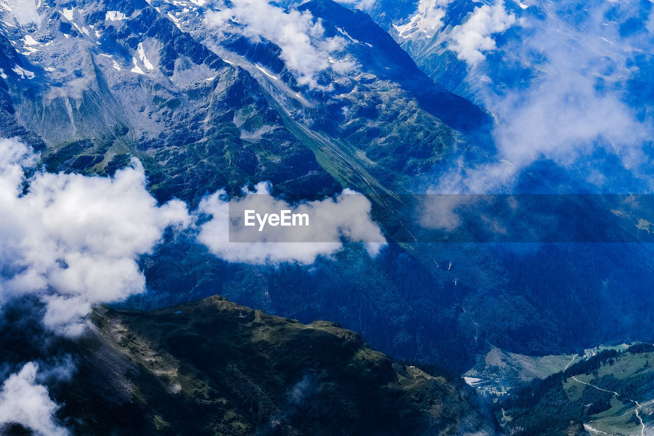AERIAL VIEW OF MAJESTIC MOUNTAINS AGAINST SKY
