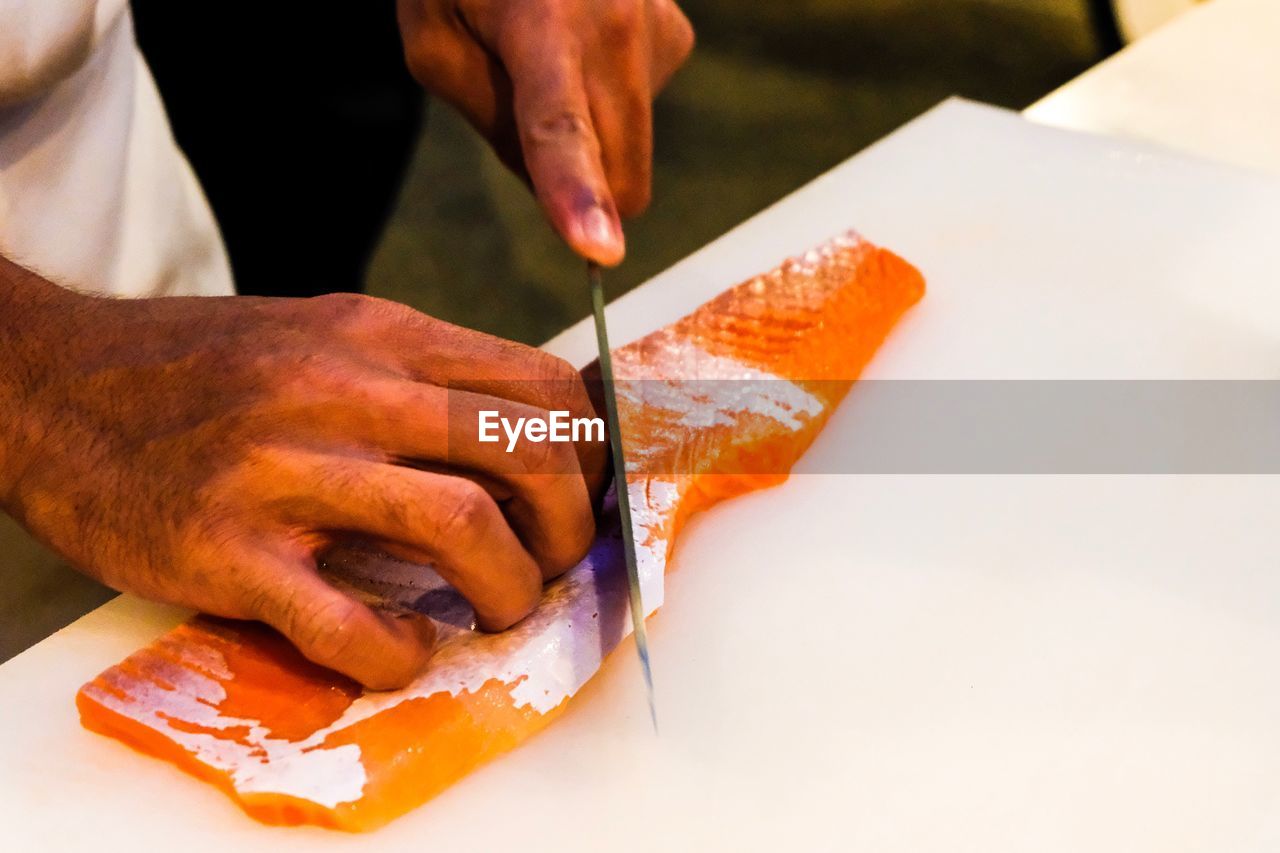 Man cutting fish on table