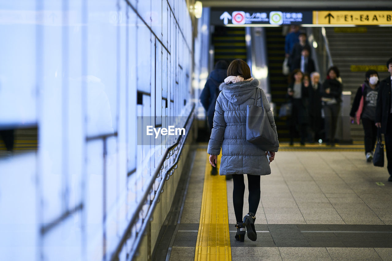 Rear view full length of woman walking at subway station