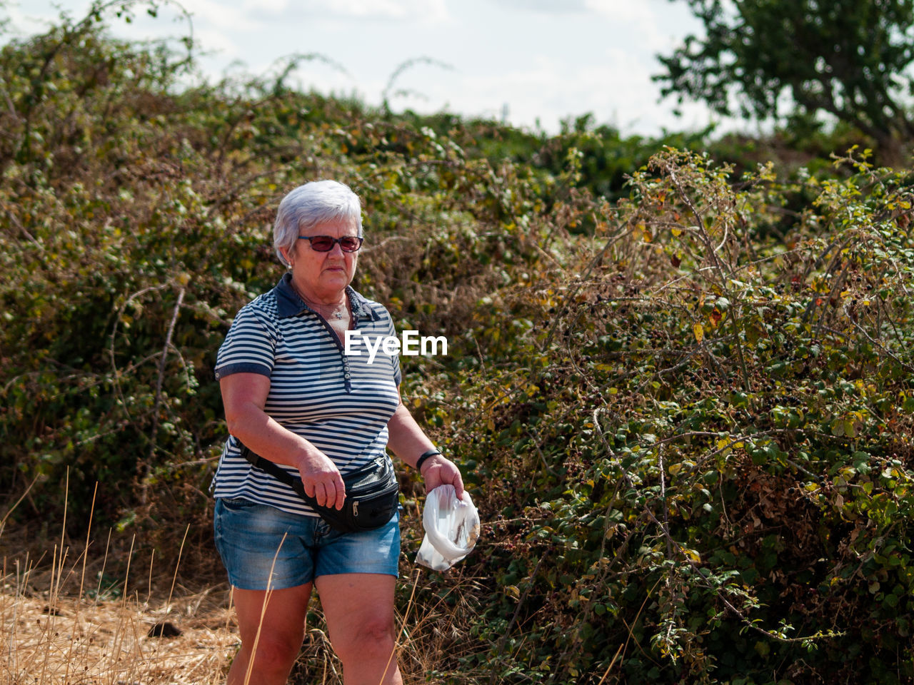 Senior woman gardening on field