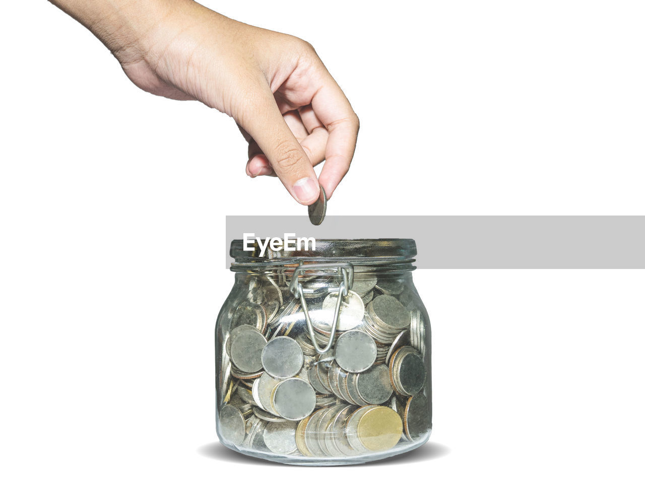 CLOSE-UP OF A HAND HOLDING GLASS JAR