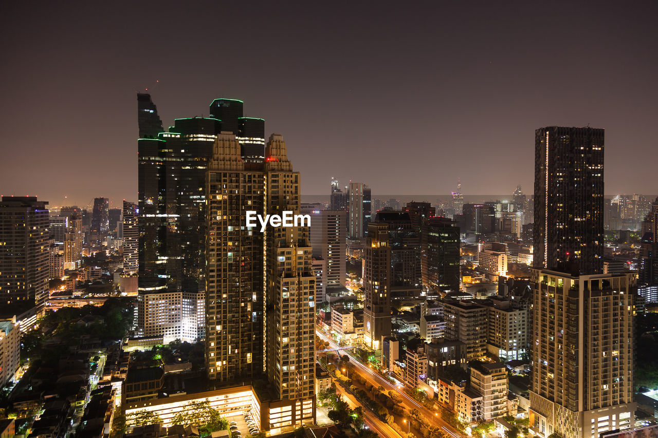 Illuminated cityscape against sky at night