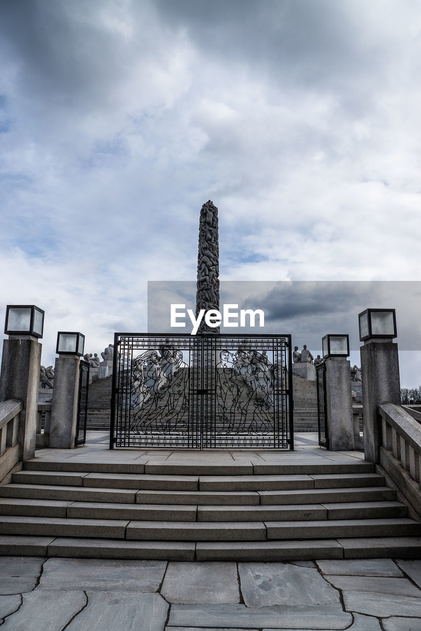 Steps by gate of vigeland sculpture park against sky