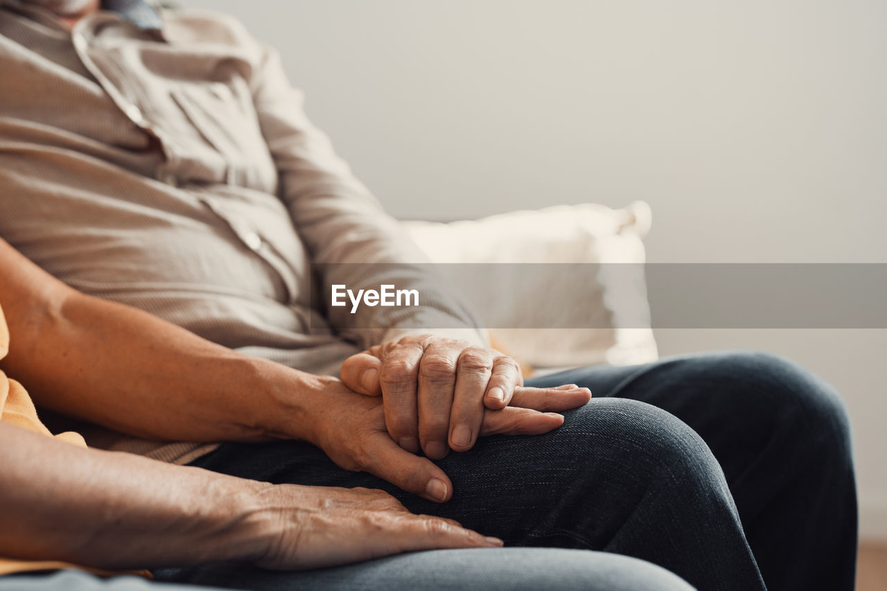 low section of woman sitting on sofa at home