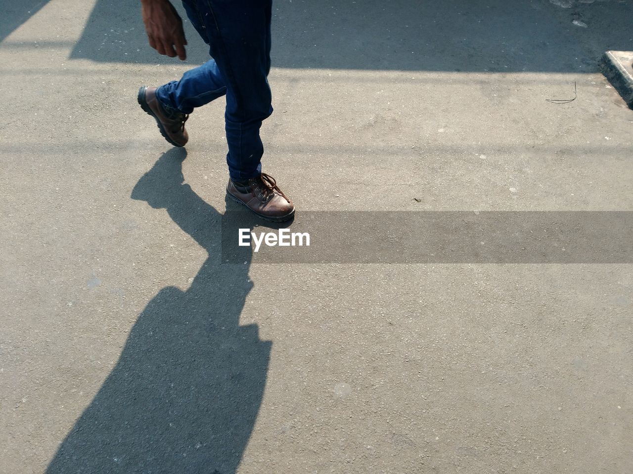 Low section of man walking on street