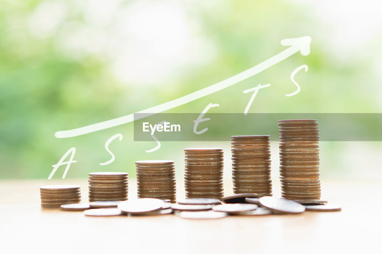 Money coins stack growing graph bank on nature background, saving finance and chart 